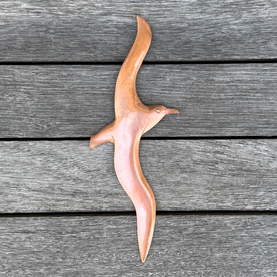 Copper Albatross bird sculpture on a wooden surface