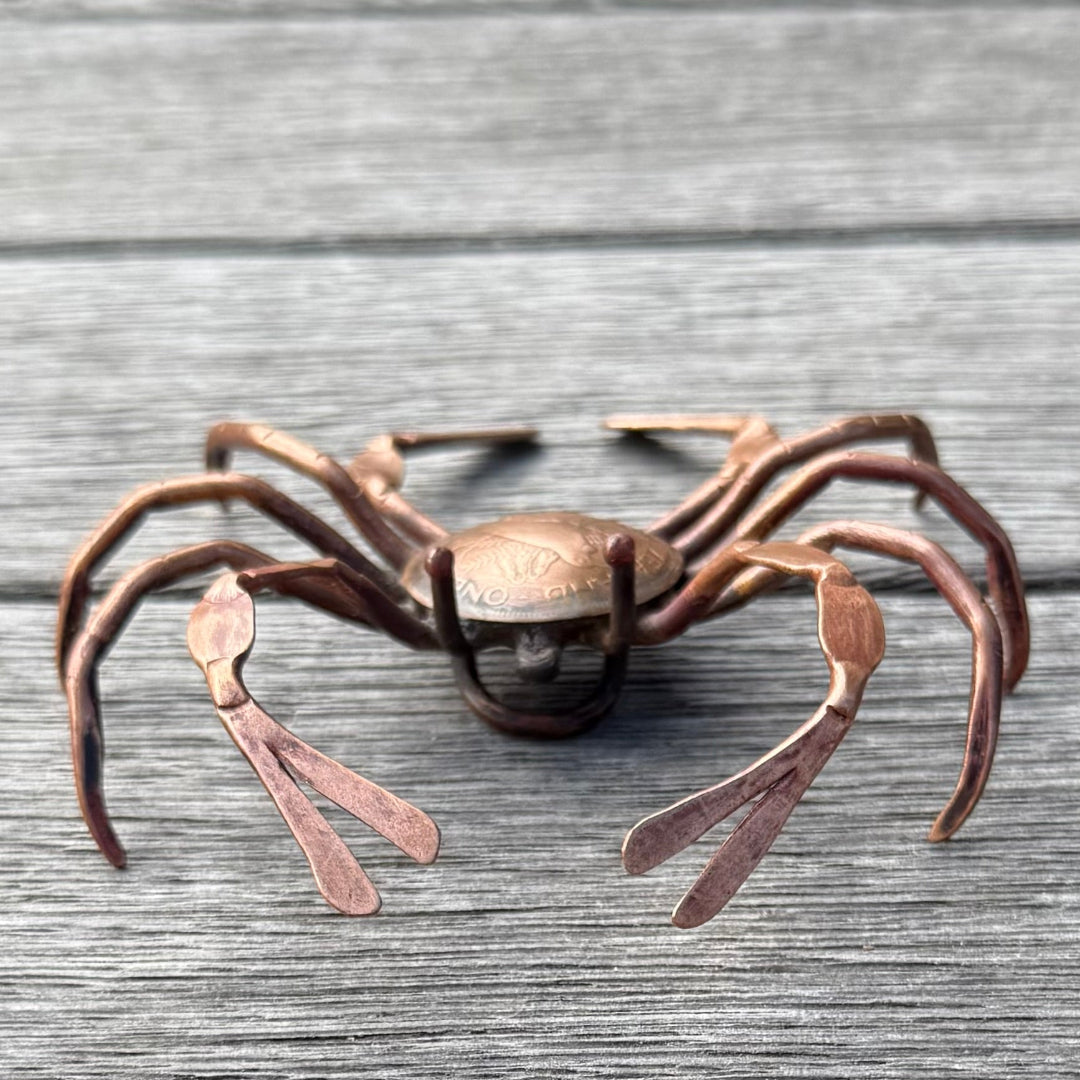 Copper crab sculpture on a wooden surface
