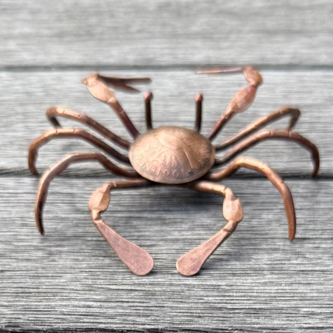 Copper crab sculpture on a wooden surface