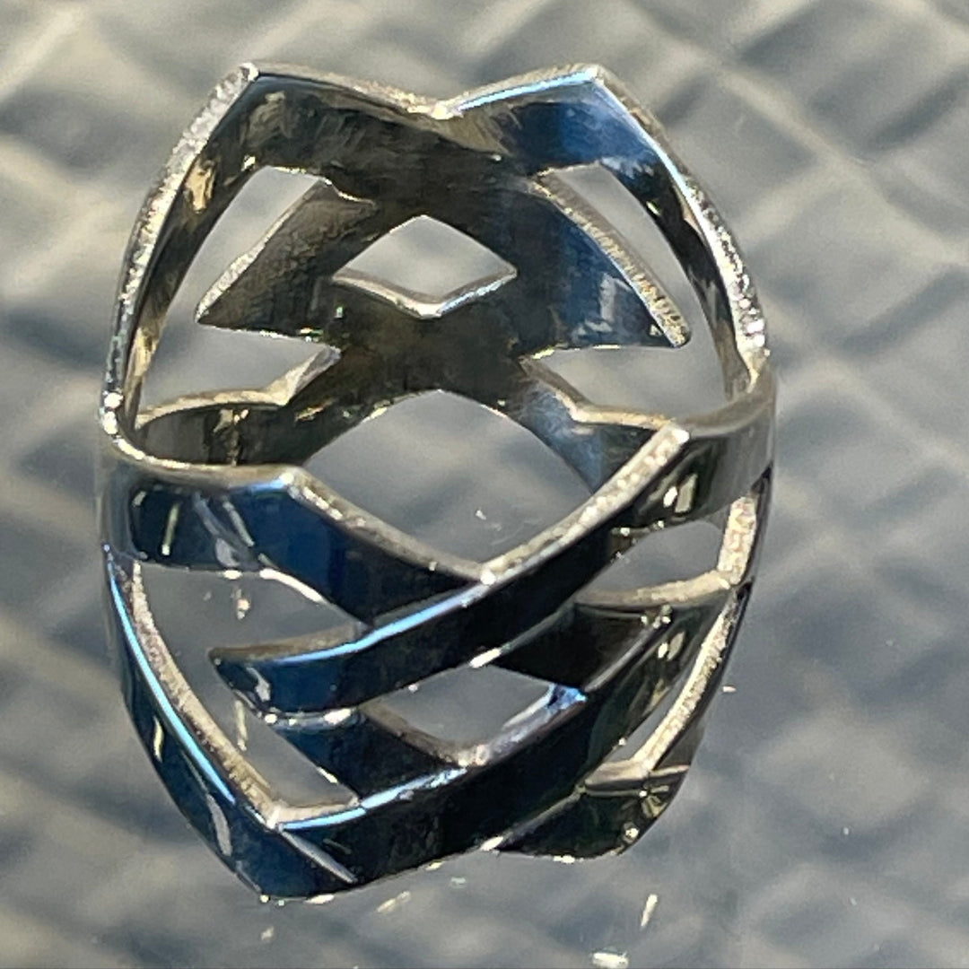 Silver ring with geometric design on a textured surface
