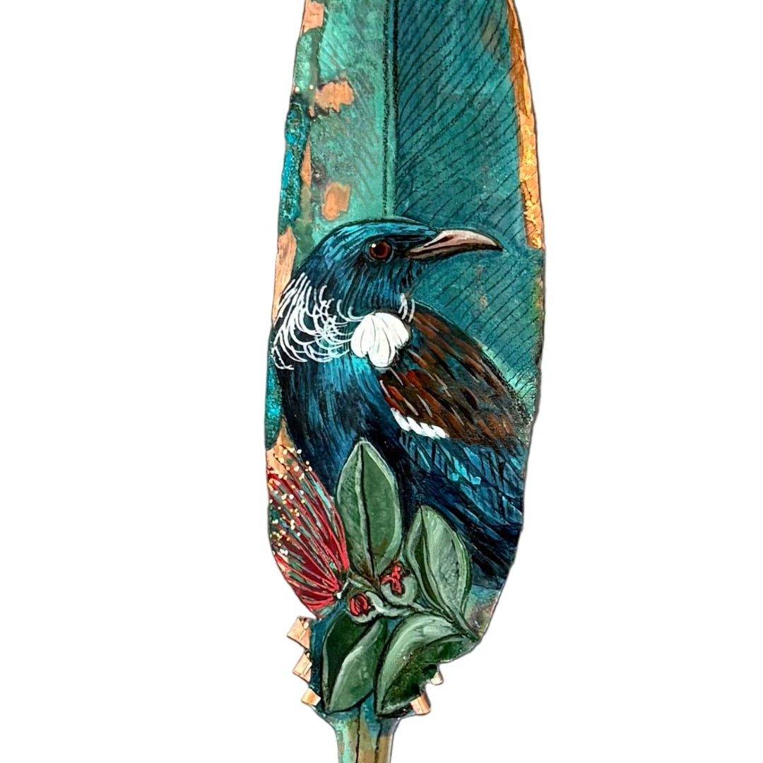 Decorative copper feather with a painted Tui bird on a white background