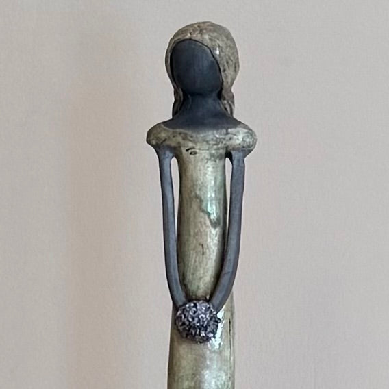 Close up view of a ceramic figurine on a plain background