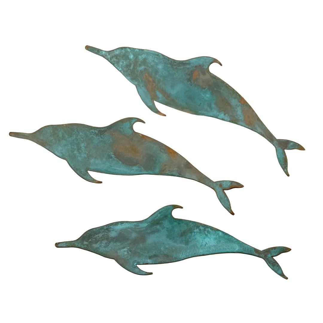 Three copper dolphins on a white 
surface