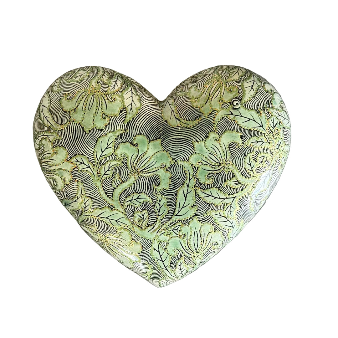 Heart-shaped ceramic wall hanging with intricate floral patterns on a white background