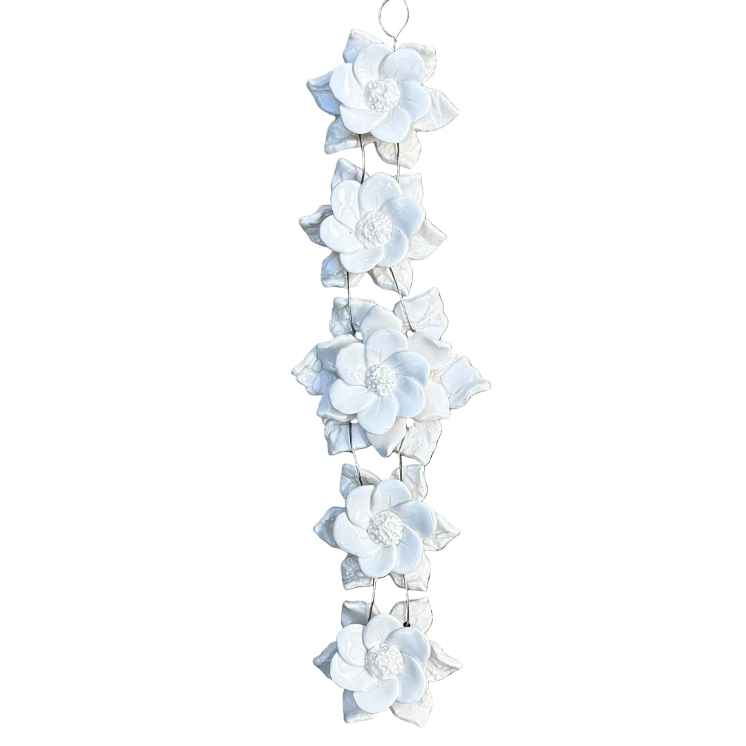 Decorative hanging with white flowers on a white surface