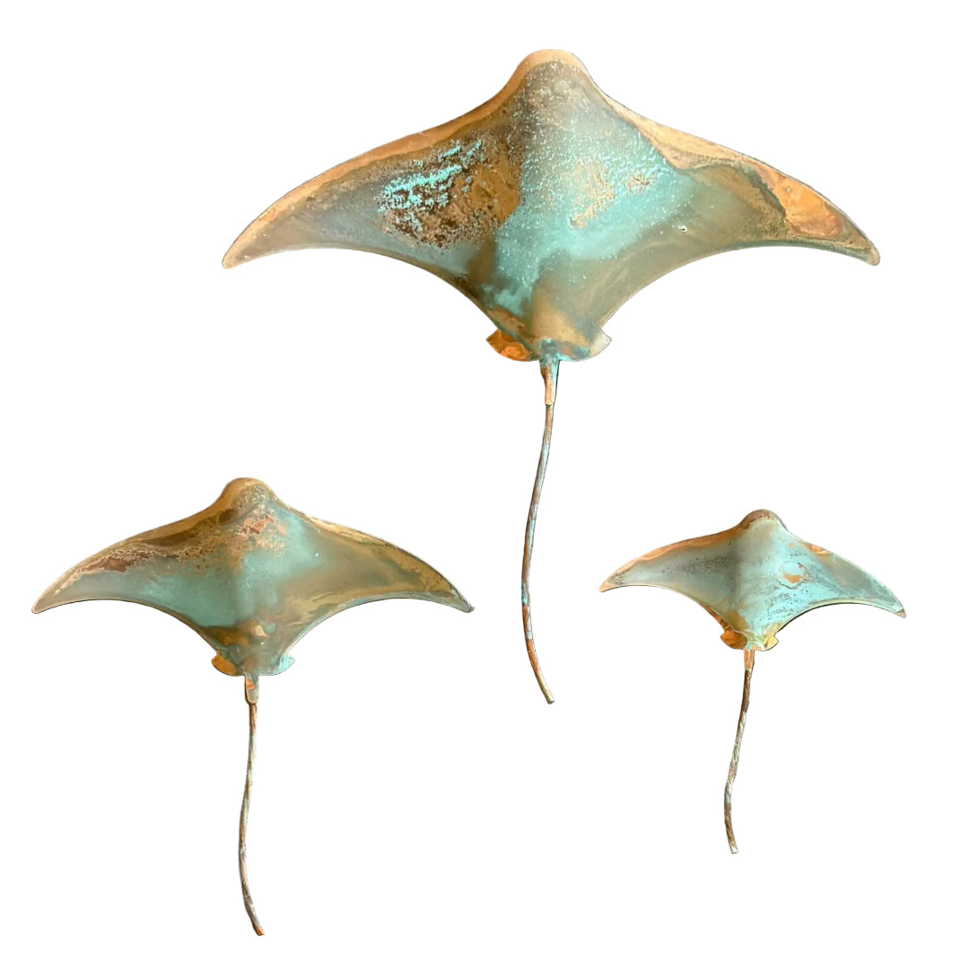 Three copper stingrays wall art on a white background 