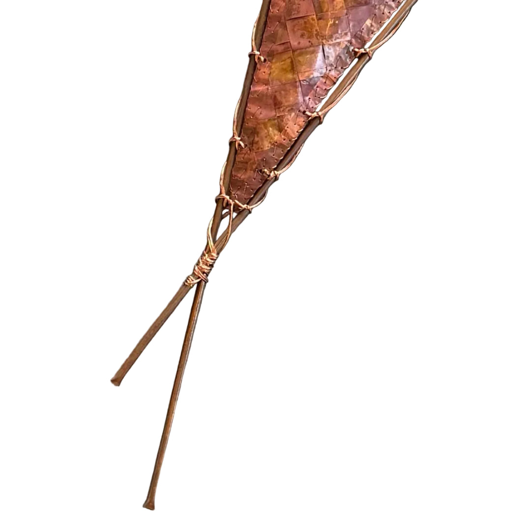Close up of the bottom section of a decorative sail-shaped woven copper wall scupture on a white background
