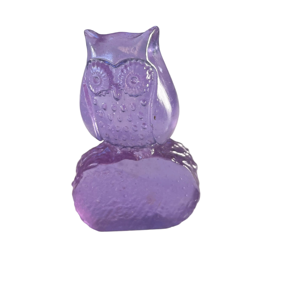 Amethyst coloured glass owl sculpture on a white surface