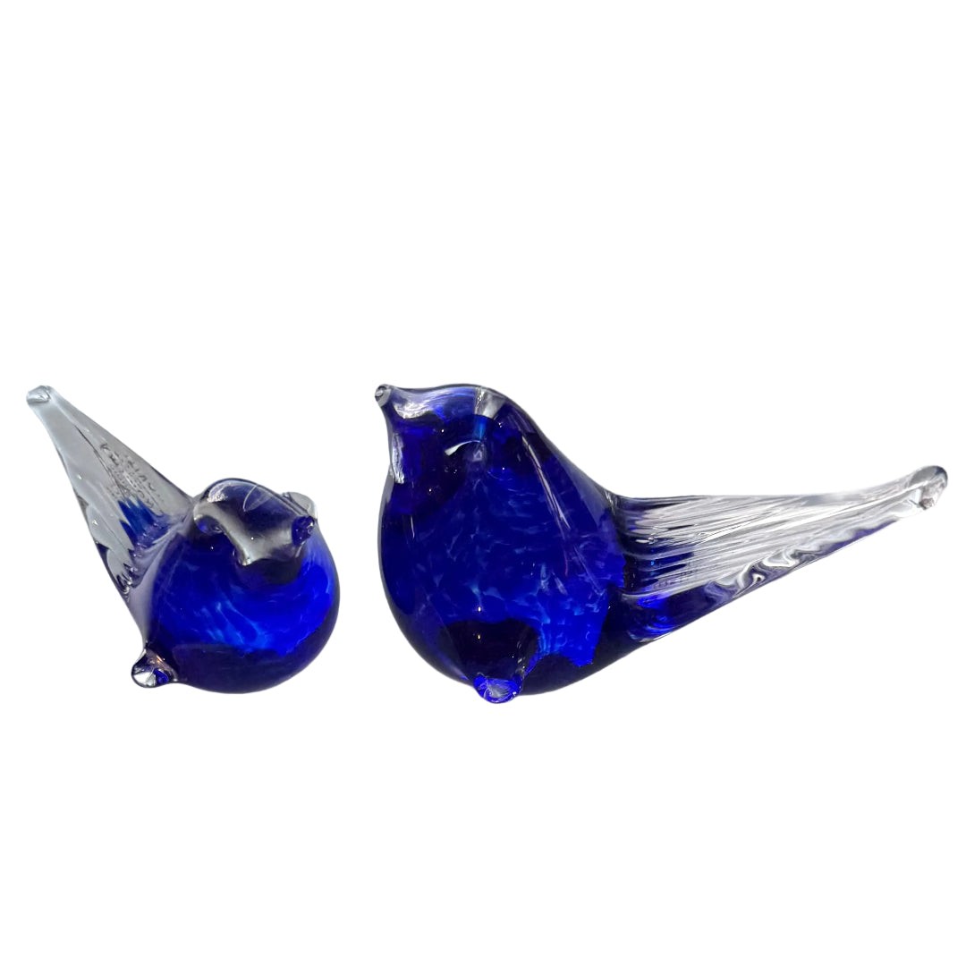 Two blue glass birds on a white background