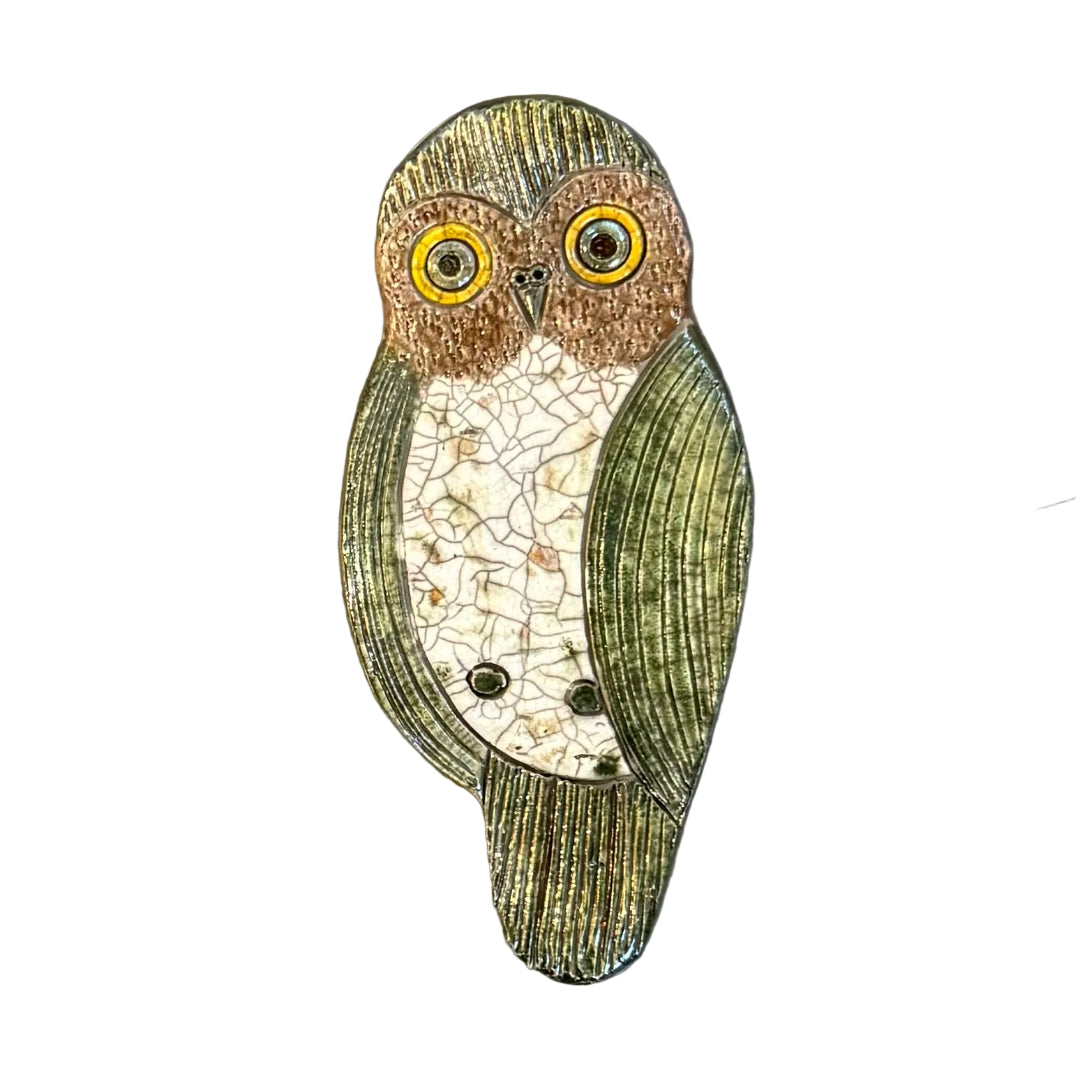 Raku fired ceramic Morepork shaped wall tile on a white background