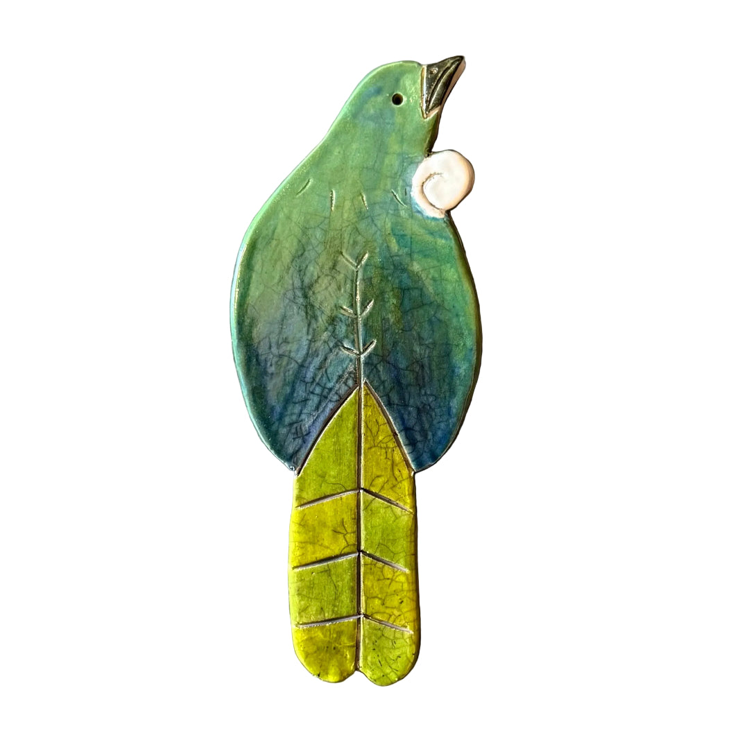 Colourful ceramic Tui shaped wall tile on a white background