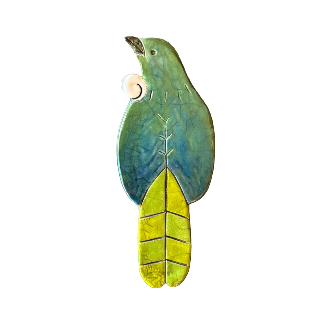 Colourful ceramic Tui shaped wall tile on a white background