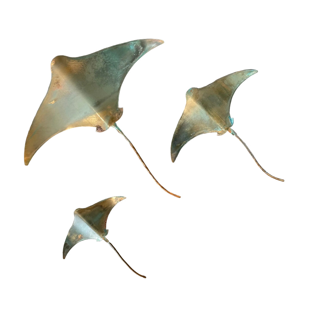Three copper stingray wall sculptures  on a white background