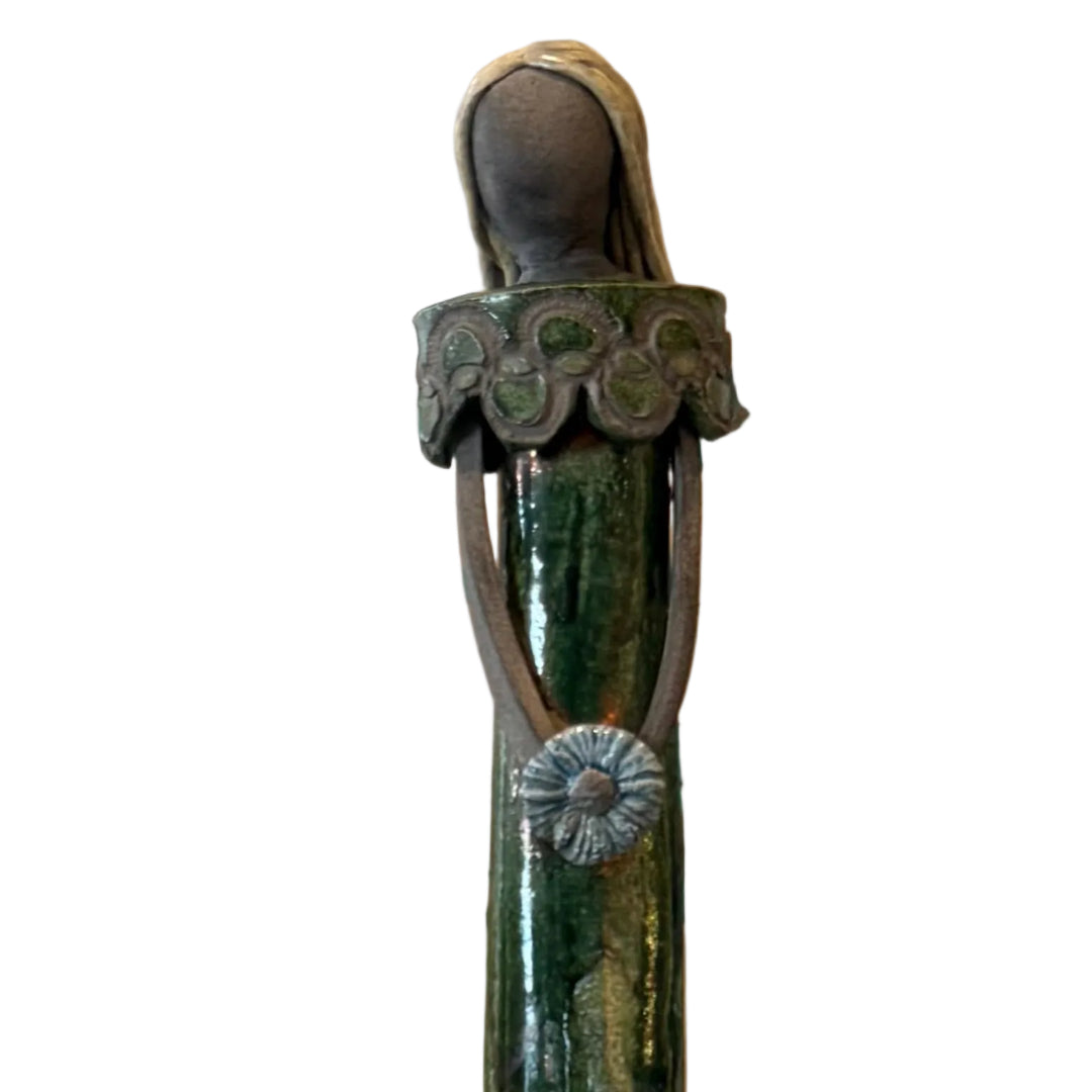 Close up view of a tall blonde lady ceramic sculpture on a white background