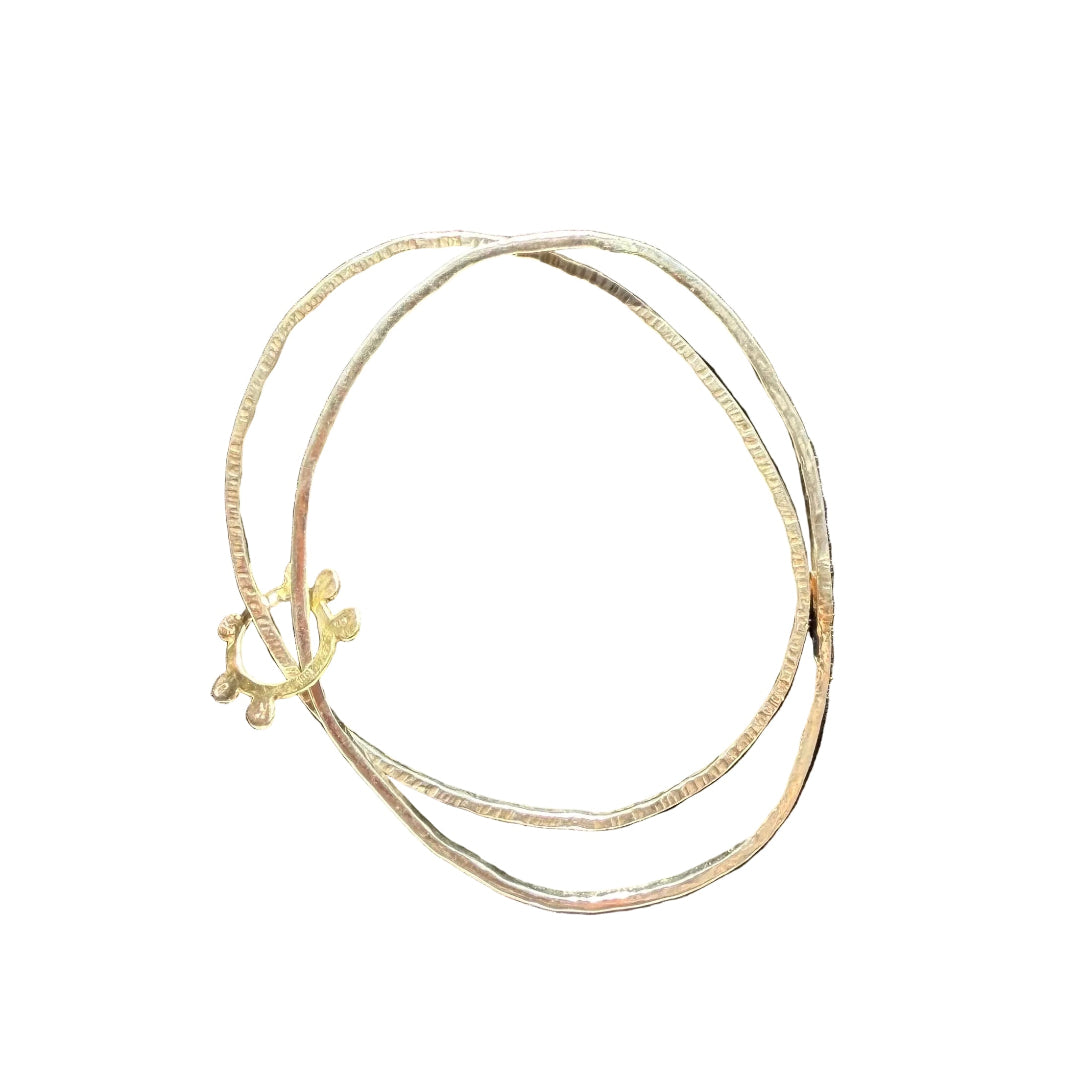 A two-layered bracelet with silver textured bands and gold-colored accents, featuring a floral Solo Sun design linking the bands.