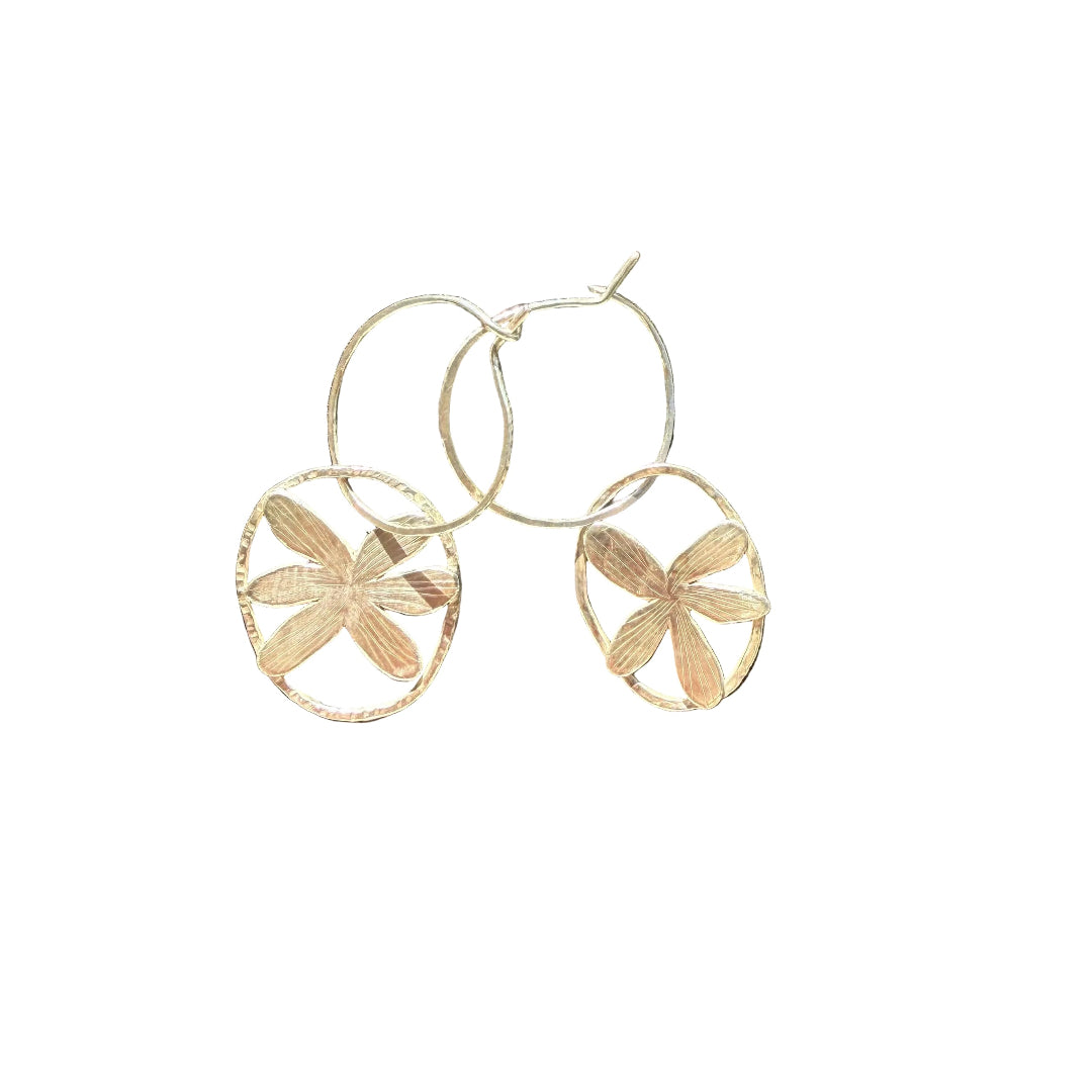 Pair of silver floral earrings on a white  surface