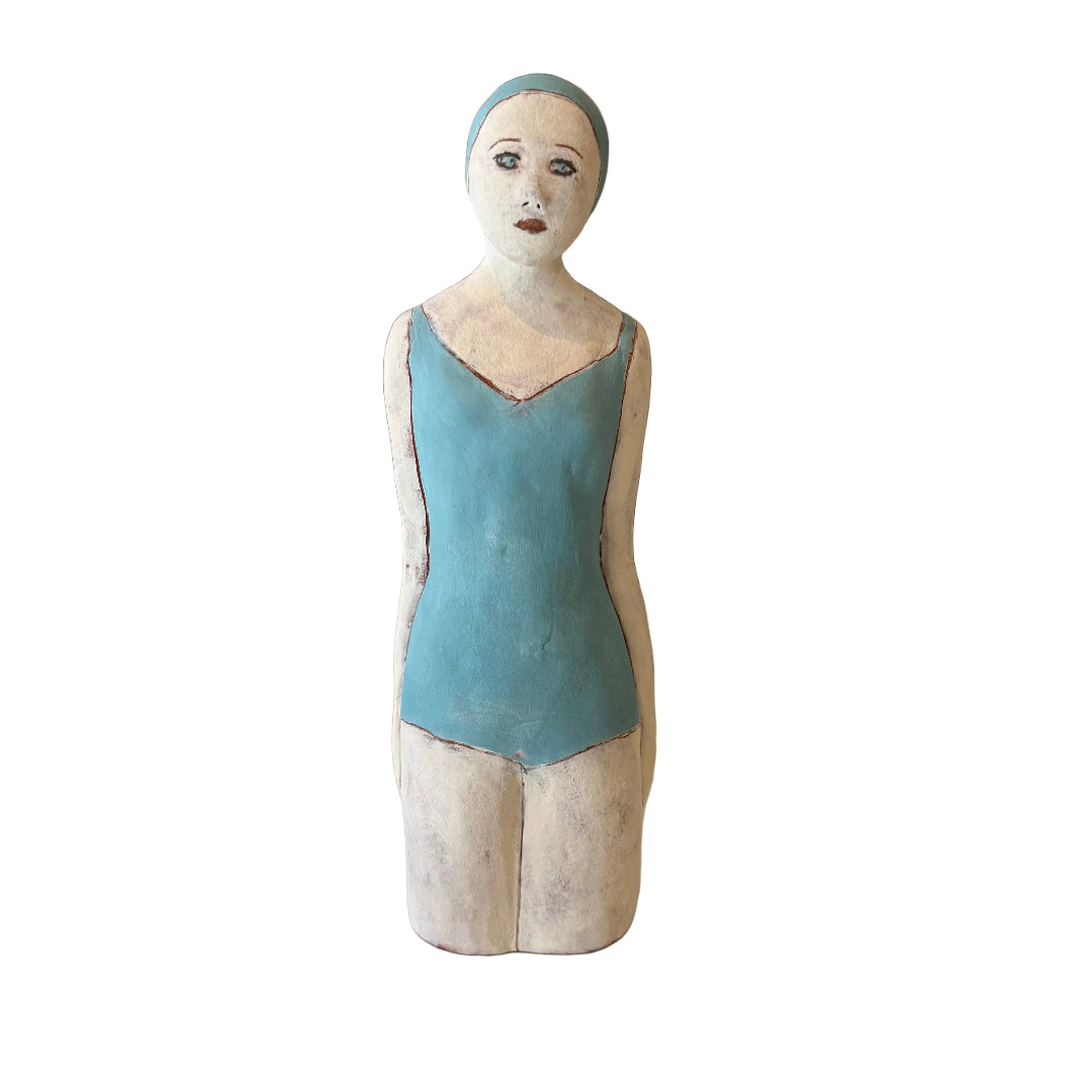 Statue of a woman in a blue swimsuit against a white background.