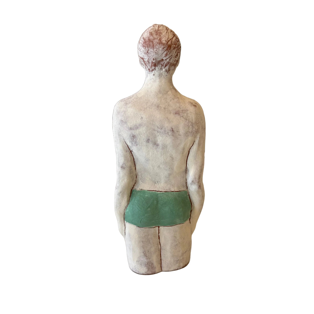 Back view of a ceramic male Swimmer in jade trunks on a white background.