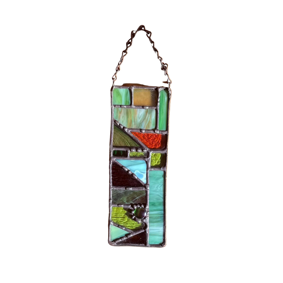 Stained glass panel with chain on a white surface