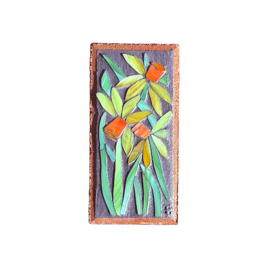 Decorative mosaic brick with floral design on a white surface