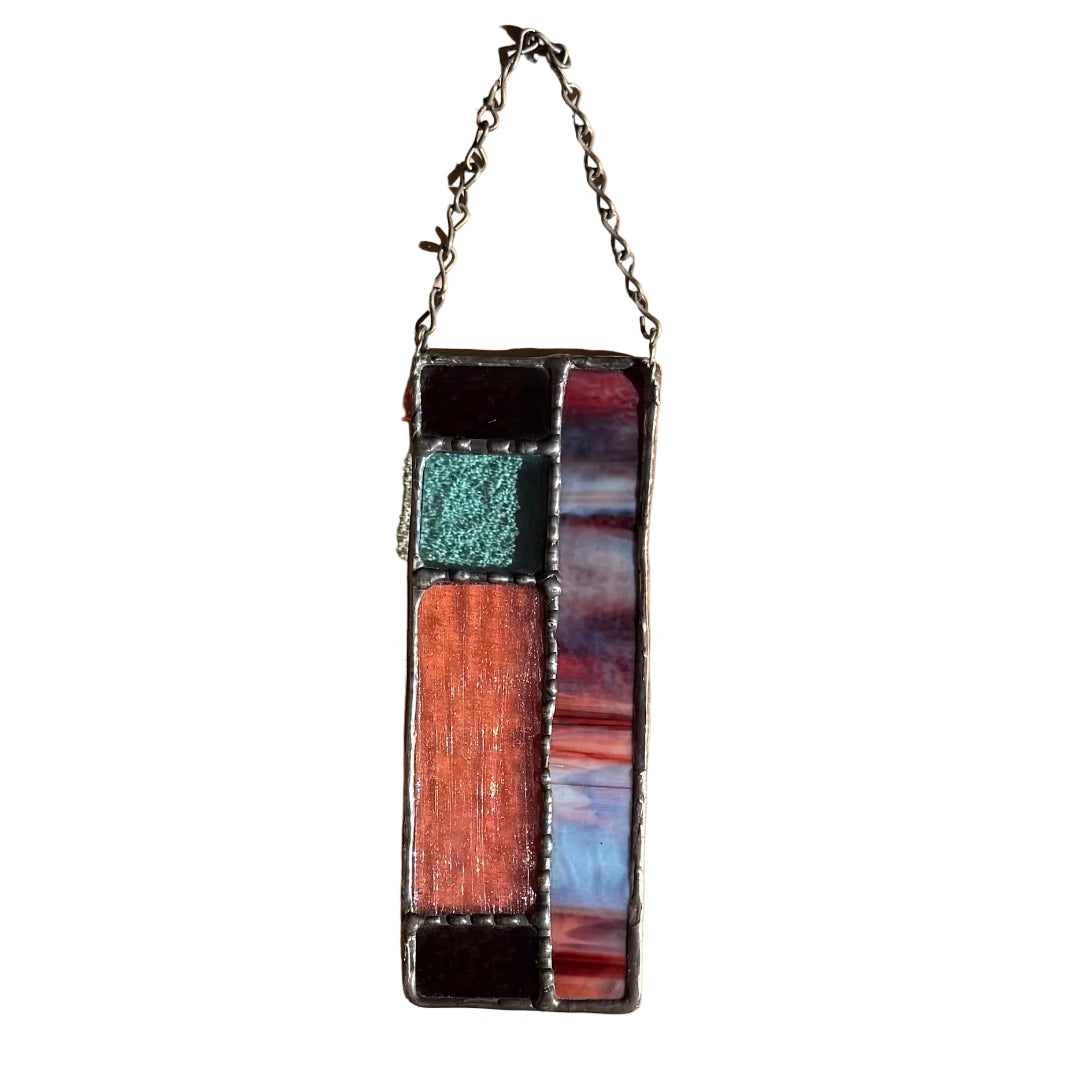 Decorative stained glass wall hanging with geometric design on a white wall
