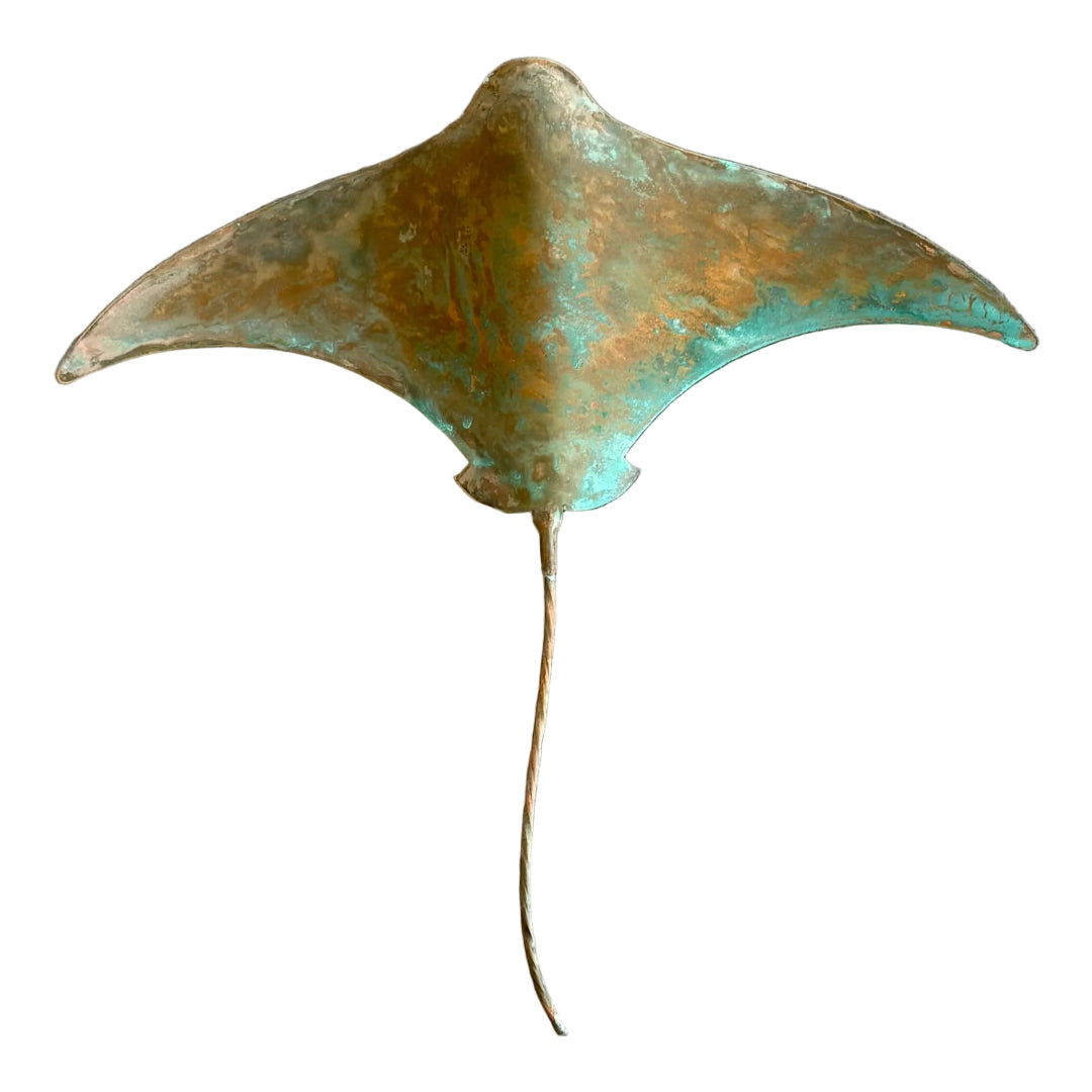 Copper stingray wall sculpture on a white surface