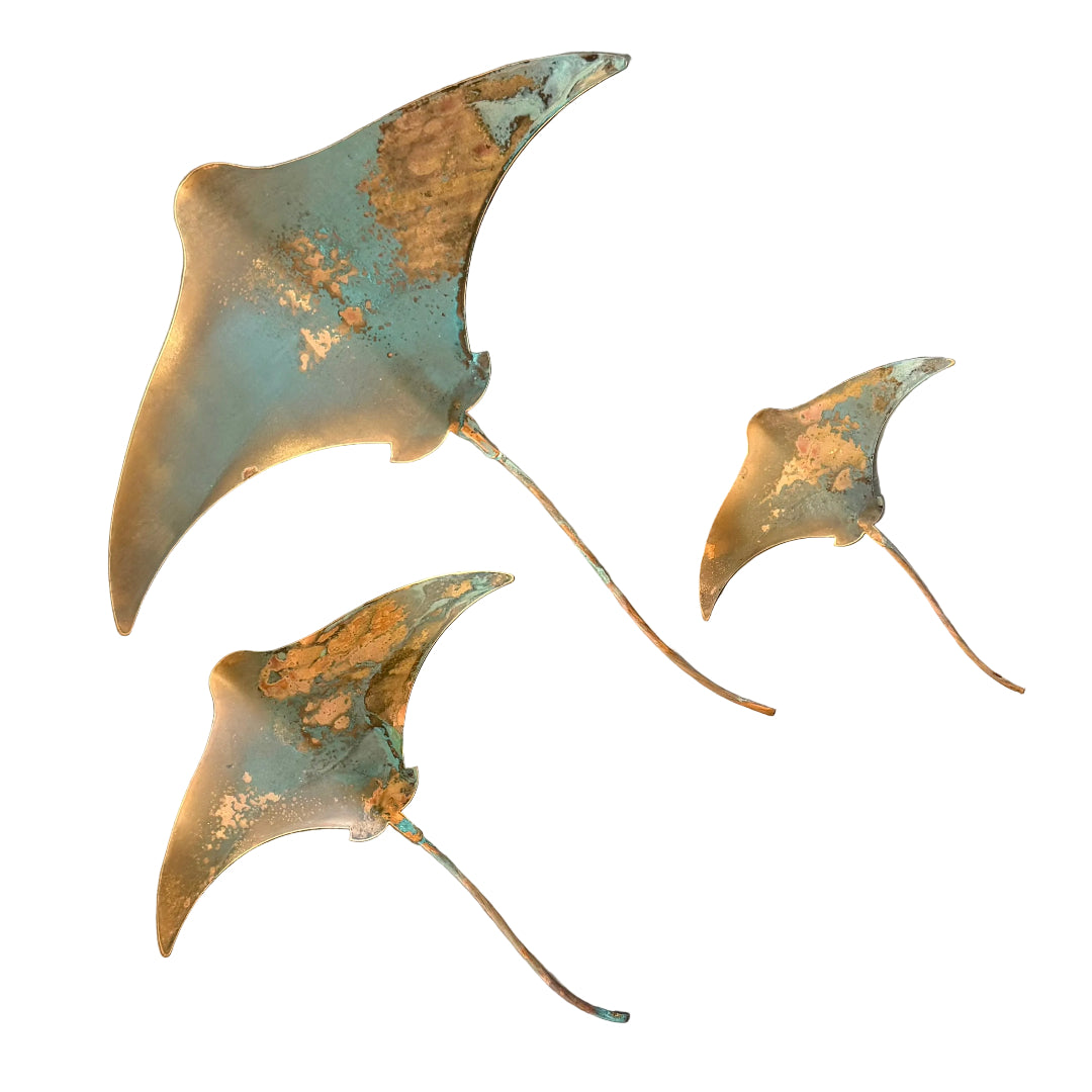 Three copper stingray wall scuptures on a white background