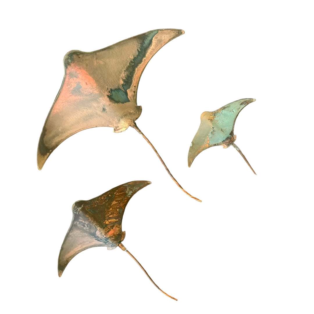 Three copper stingray wall scuptures on a white background