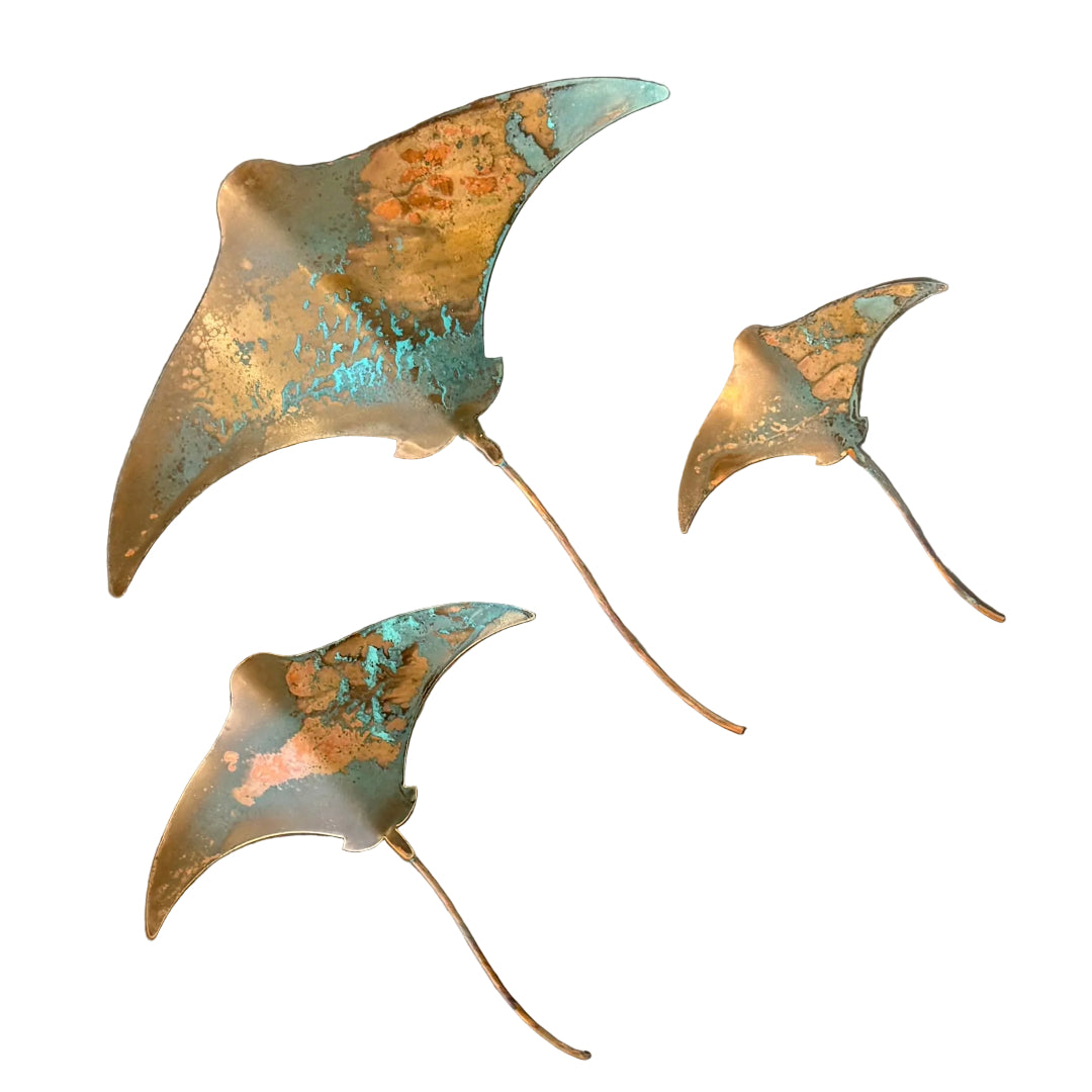 Three copper stingray wall scuptures on a white background