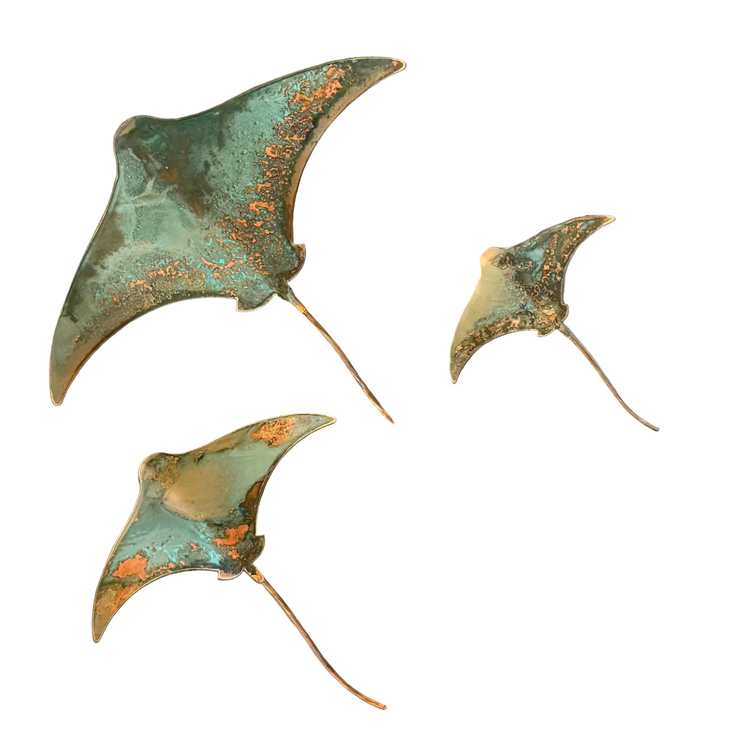 Three copper stingray wall scuptures on a white background