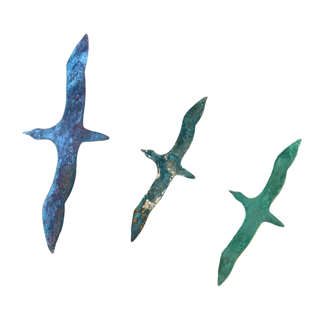 Three copper gannets wall scupture on a white wall