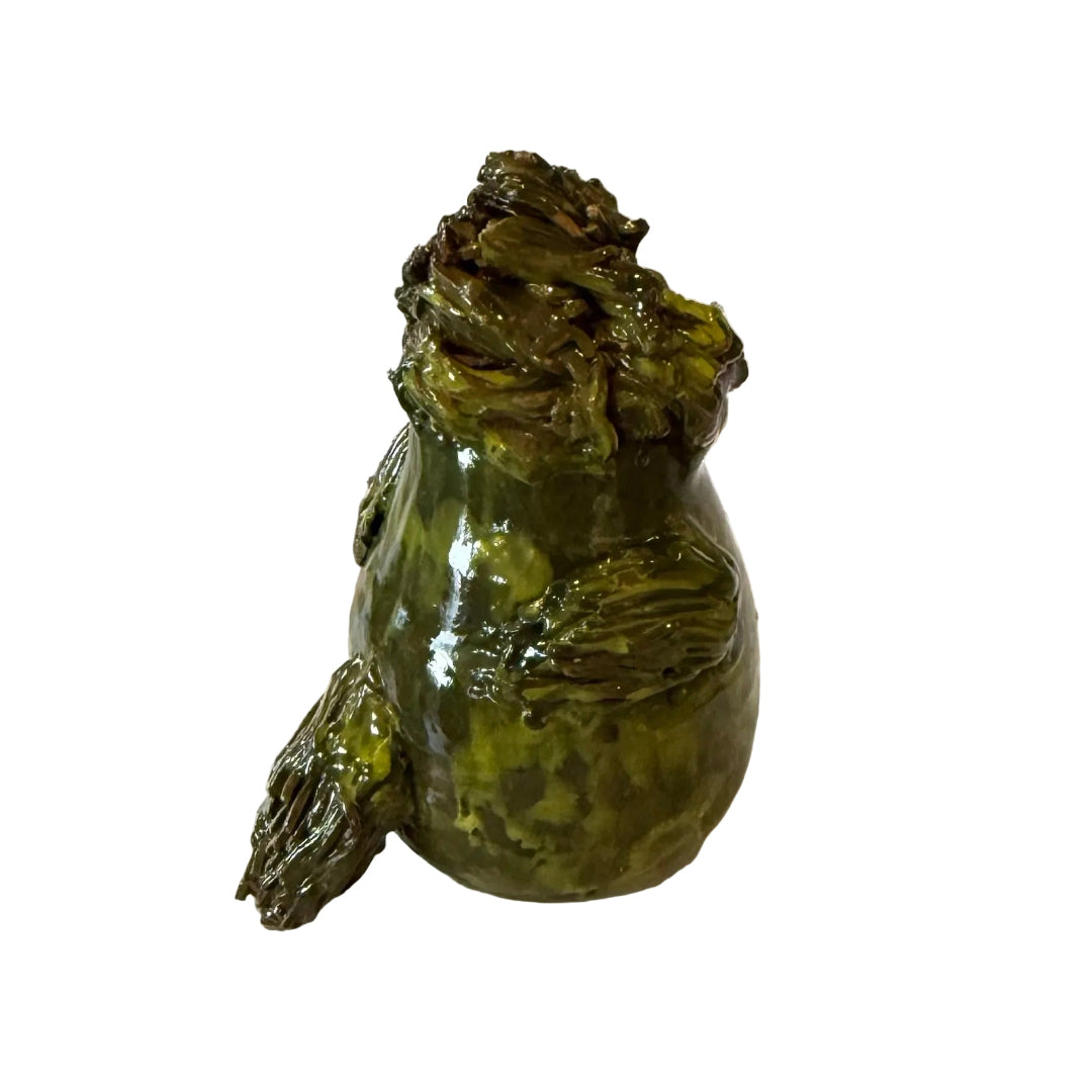 Ceramic Kakapo bird sculpture with an orange beak on a white background