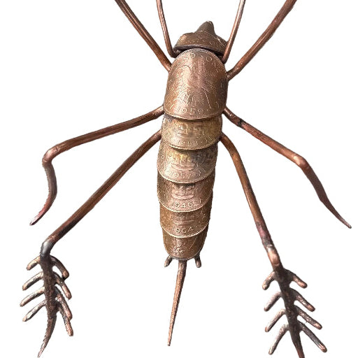 Copper Weta sculpture on a white surface