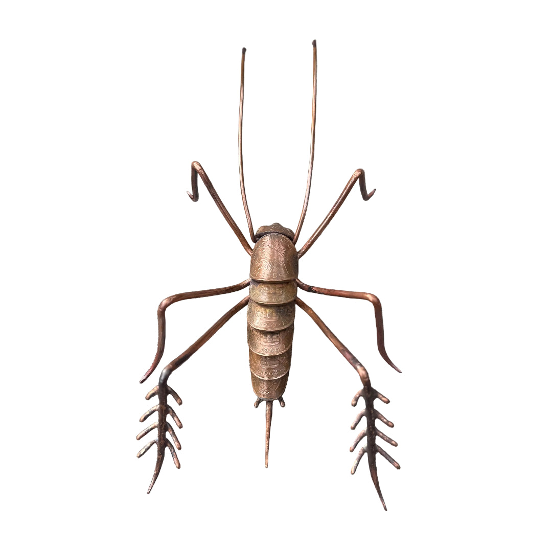 Copper Weta sculpture on a white surface