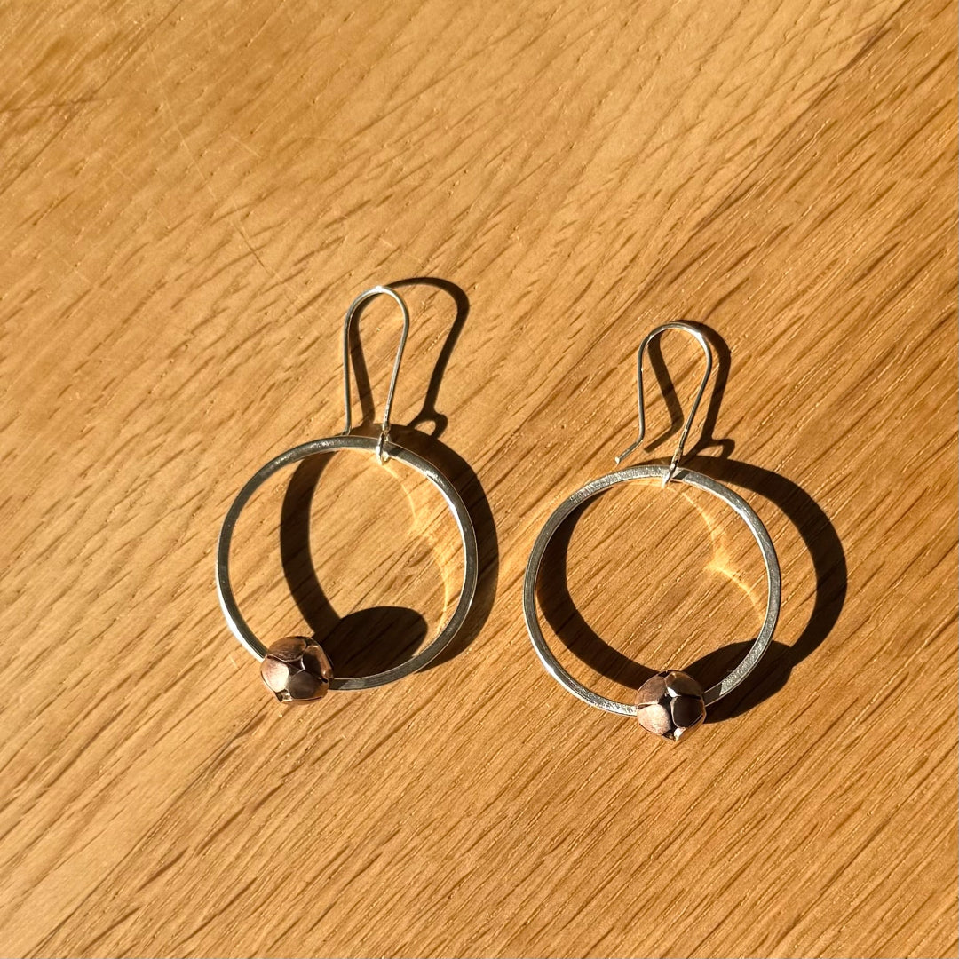 Silver hoop earrings on a wooden surface