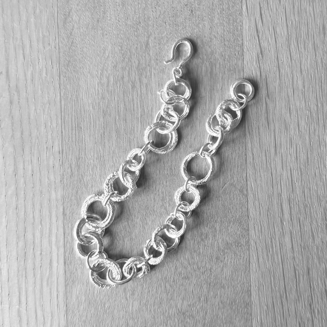 Silver chain bracelet on a wooden surface