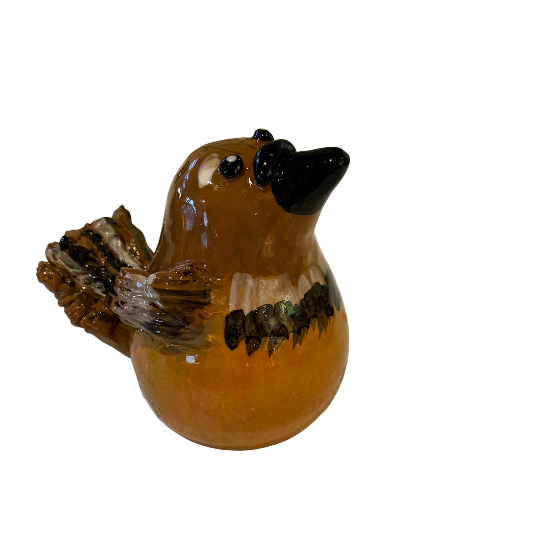 Side view of a ceramic Fantail sculpture with a black beak on a white background