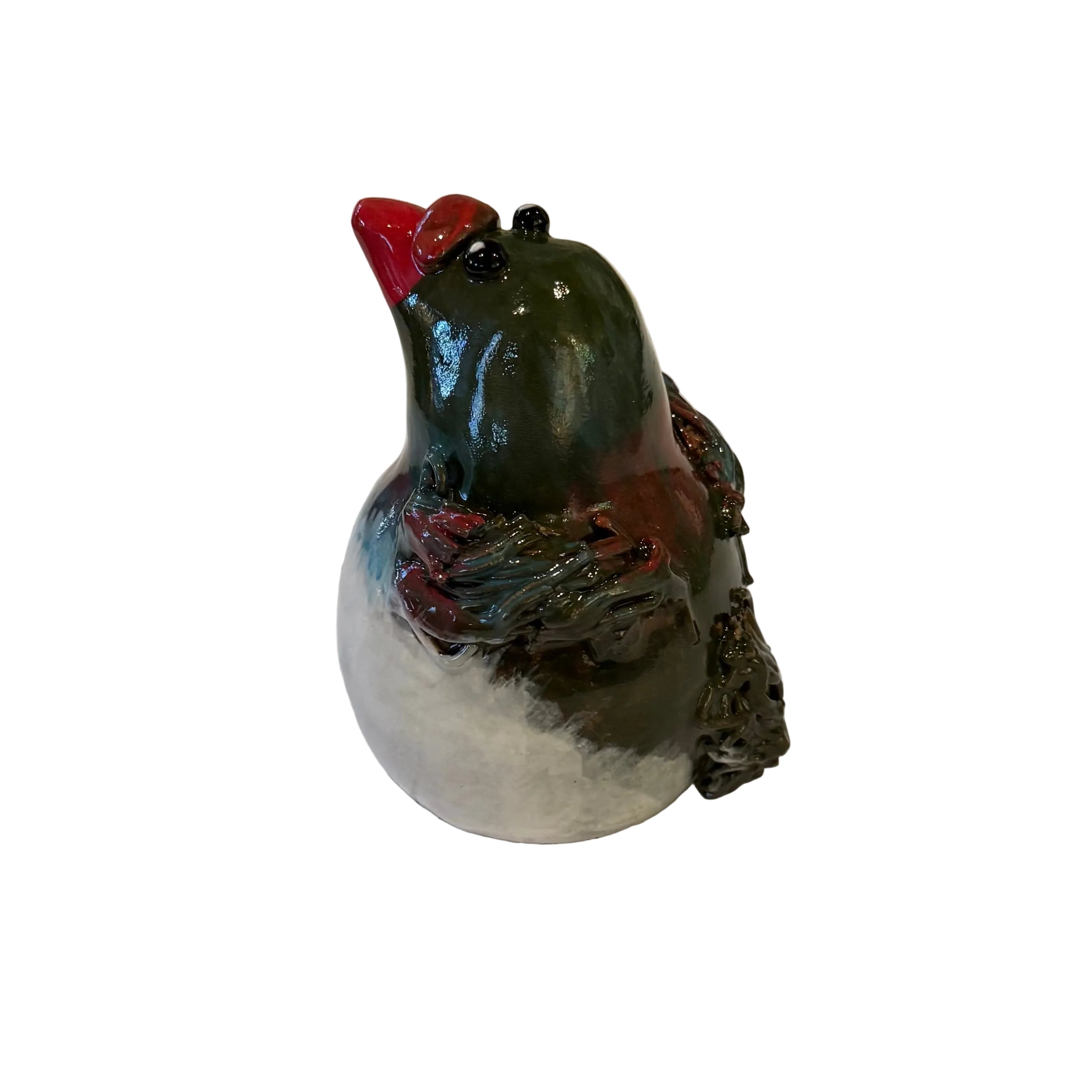 Side view of a ceramic Kereru bird sculpture with a red beak on a white background