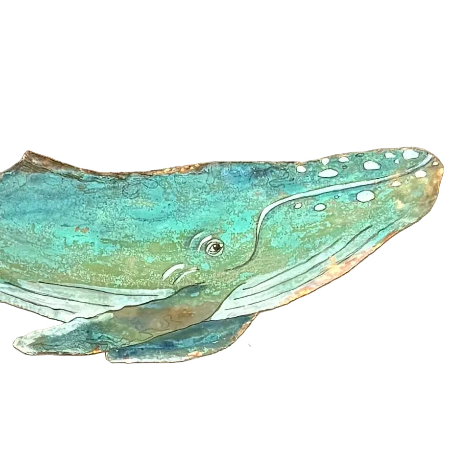 A close up of a copper whale wall art piece with a textured, weathered finish in shades of teal, green, and brown, mounted on a white wall.
