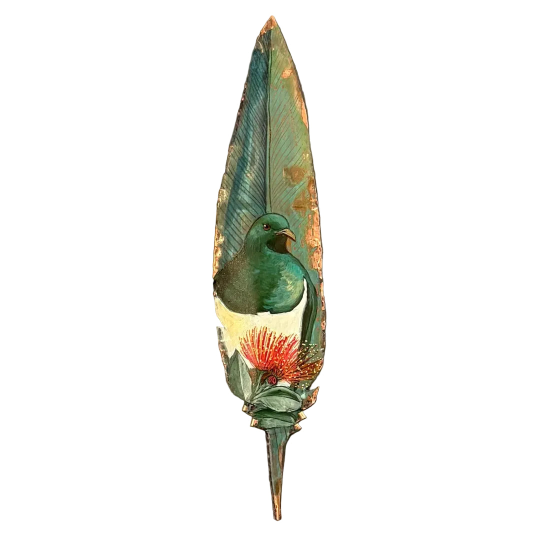 A copper wall feather sculpture, featuring a painted green and white Kereru bird with a red-orange flower, mounted on a white wall.