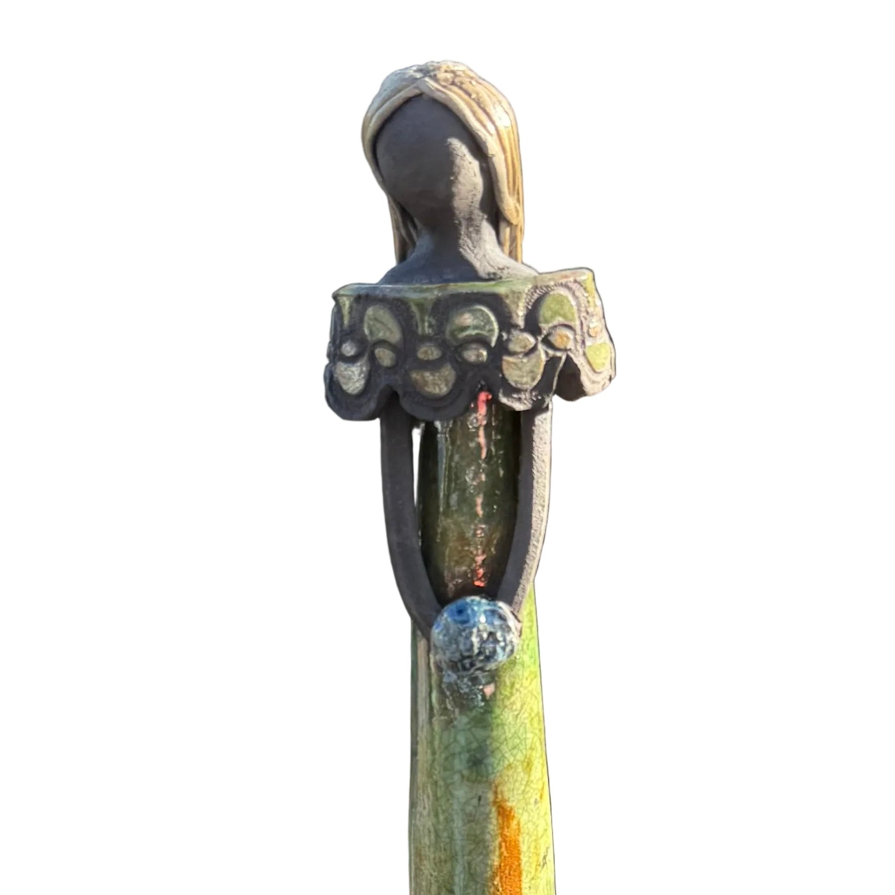 A tall, slender decorative statue with a stylized female figure. 