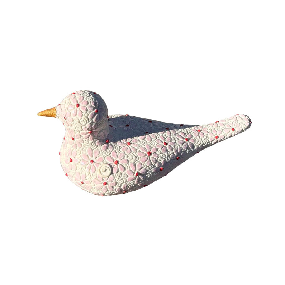 A decorative white ceramic bird figurine with a pink daisy flower pattern and a small gold beak, resting on white background.