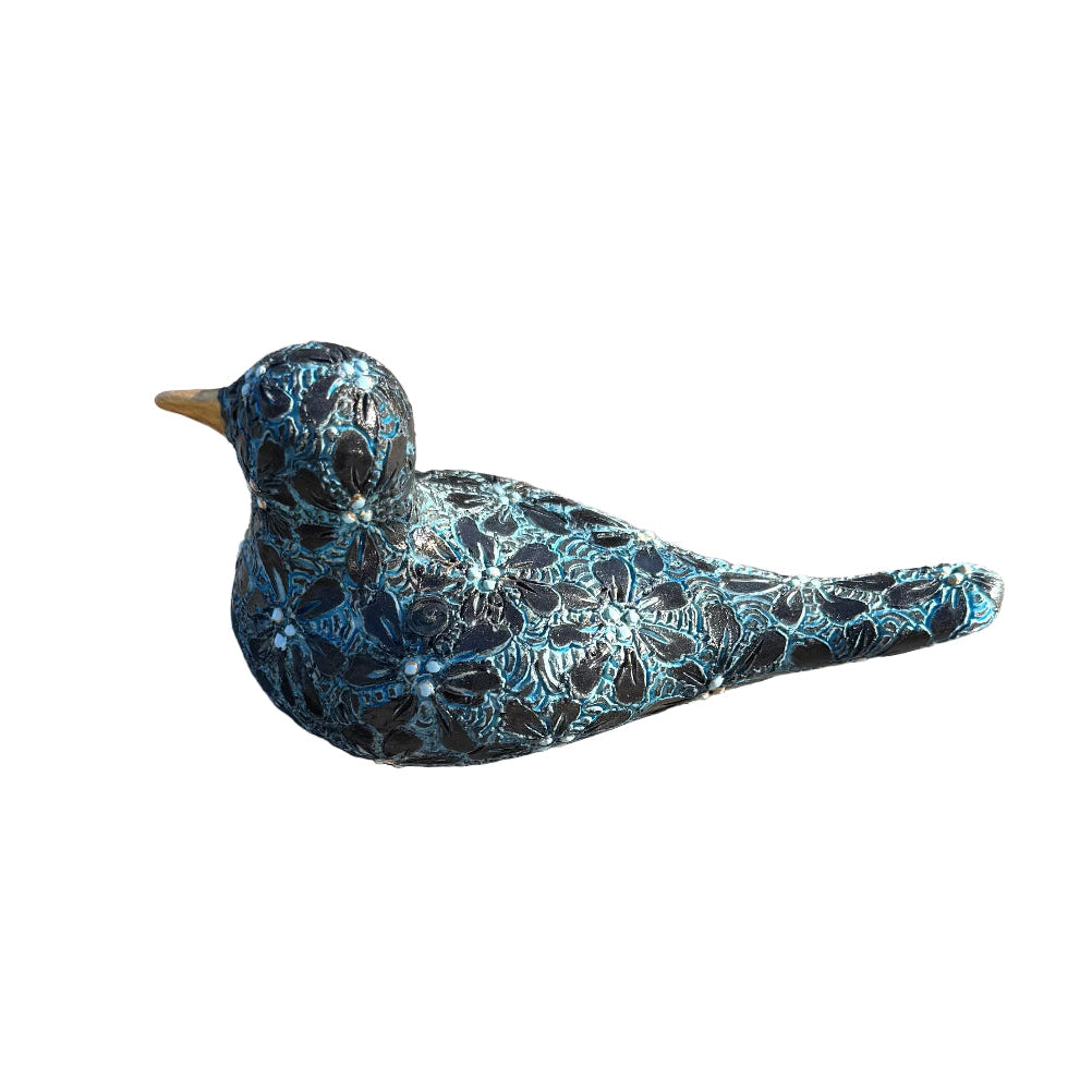 A decorative ceramic bird figurine with a black and turquoise flower pattern and a small gold beak, resting on white background.
