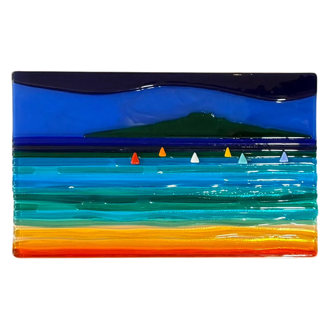 Glass wall panel of Rangitoto with sand, sea and boats.