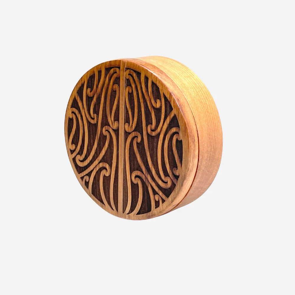Wooden object with intricate carvings on a white background
