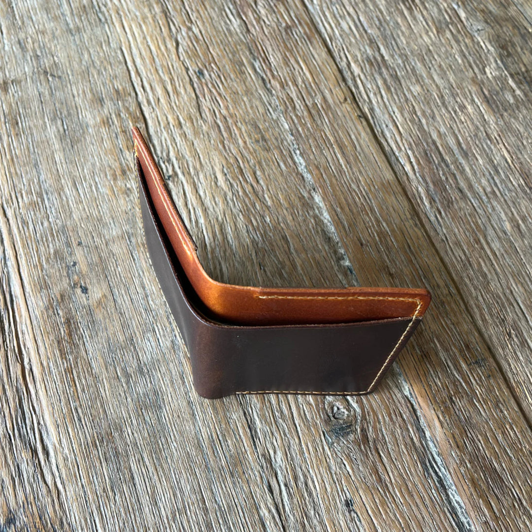Brown leather wallet clip on a wooden surface