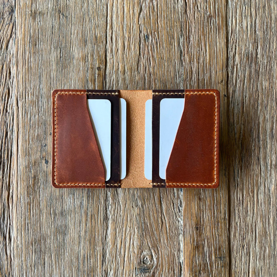 Brown leather cash & cardholder with cards on a wooden surface