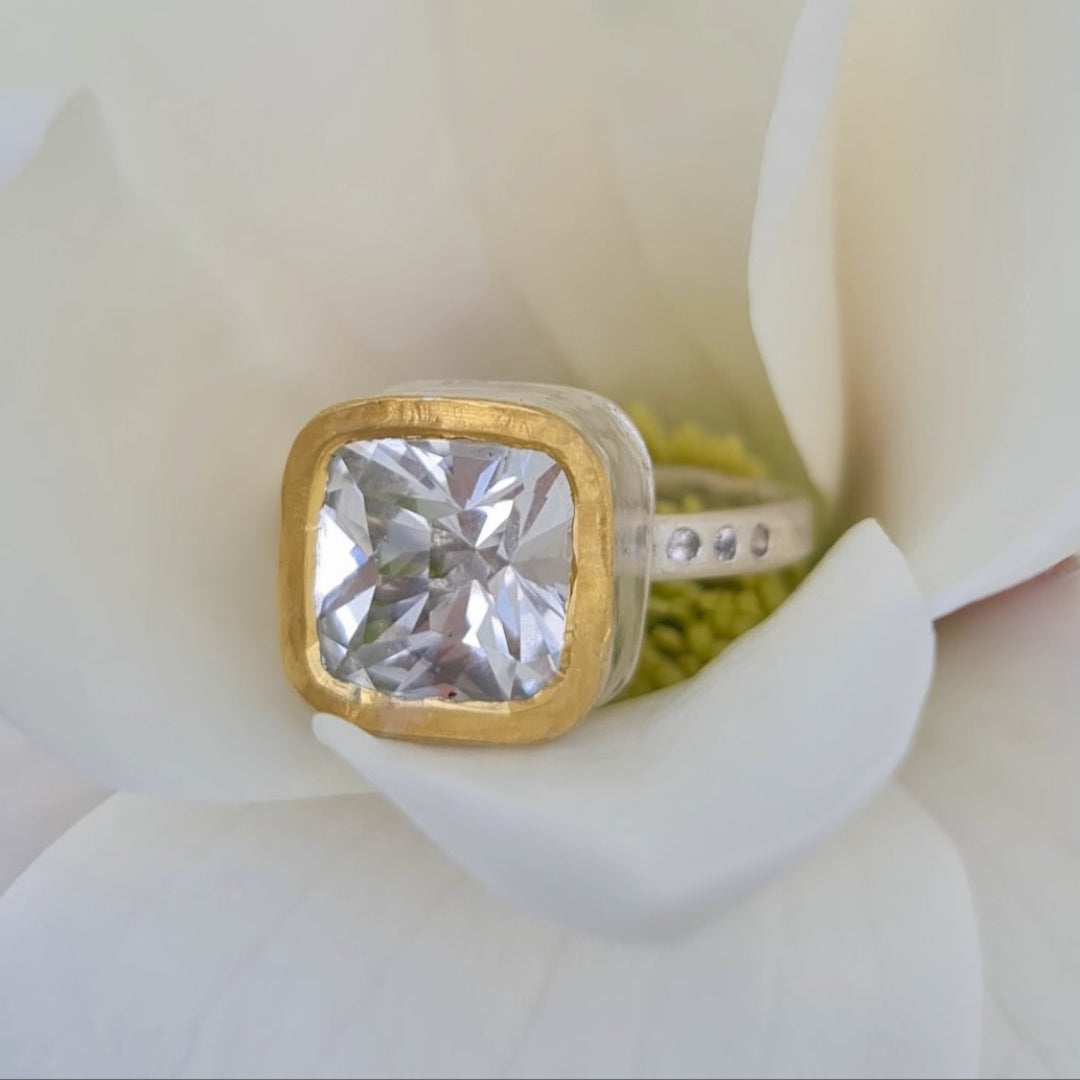 Gold & silver ring with a large topaz on a white background