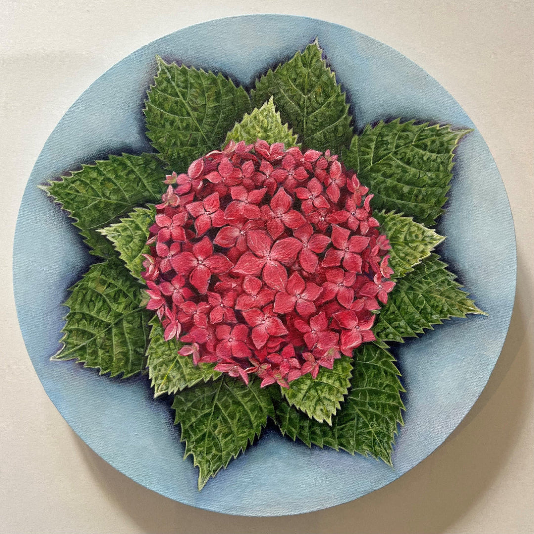 Artistic depiction of a pink flower surrounded by green leaves on a circular blue background