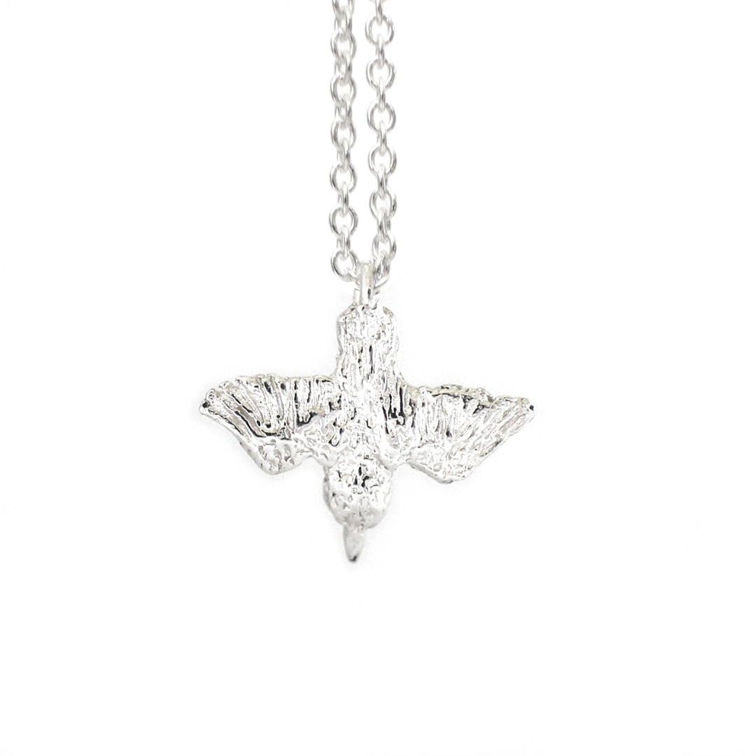 Shiny Silver Diving Kingfisher pendant on a chain against a white background